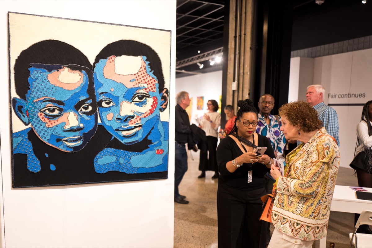 Attendees at the 1-54 Contemporary African Art Fair in New York look at various artworks.