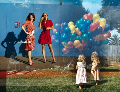 A double-exposure image of two young girls holding balloons standing in front of two women looking out into the distance.