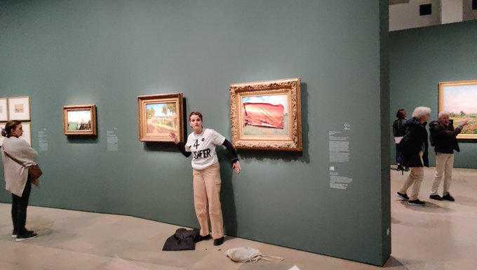 A protestor from Riposte Alimentaire at the Musée D'Orsay on June 1. The protestor  covered Claude Monet's 1873 painting Poppies at Argenteuil with a large sticker.